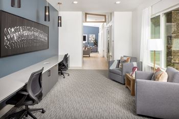 a home office with a blue wall and gray carpet